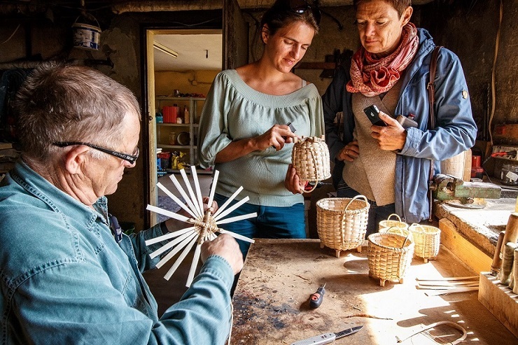 A photo from the basketmaker's workshop in Jaworzynka. In the photo, the master in the company of the local association Serfenta
