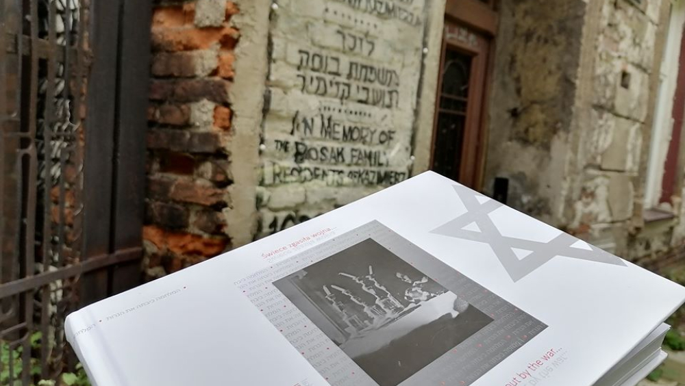 In the photo, the candles were extinguished by a book against the background of Jewish matzevot.