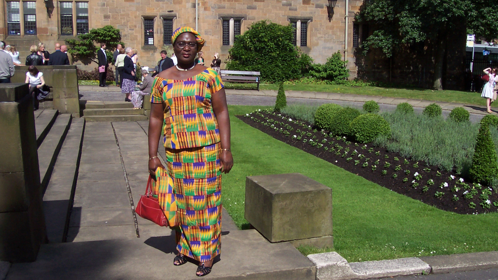 Mary Osei-Oppong in a colourful dress standing in a garden