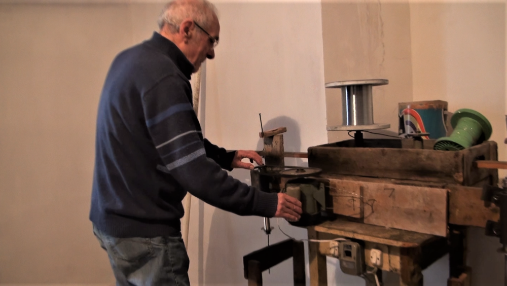 Au boulot. Giulio D’Addario montre le fonctionnement de l’une des machines qu’il a luimême inventées pour fabriquer des cordes musicales métalliques. Salle nuovo, 2 avril 2016. Photo de Giovanni Agresti. Archives Centro Studi Sociolingua.
