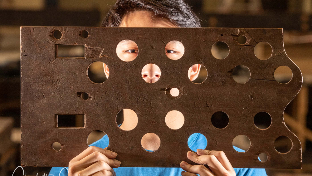 Liverpool Blue Coat School Organ Scholar SIMON CHEUNG with an organ pipe rack from the dismantled Father Willis organ photographed for The Daily Telegraph national UK news paper. 