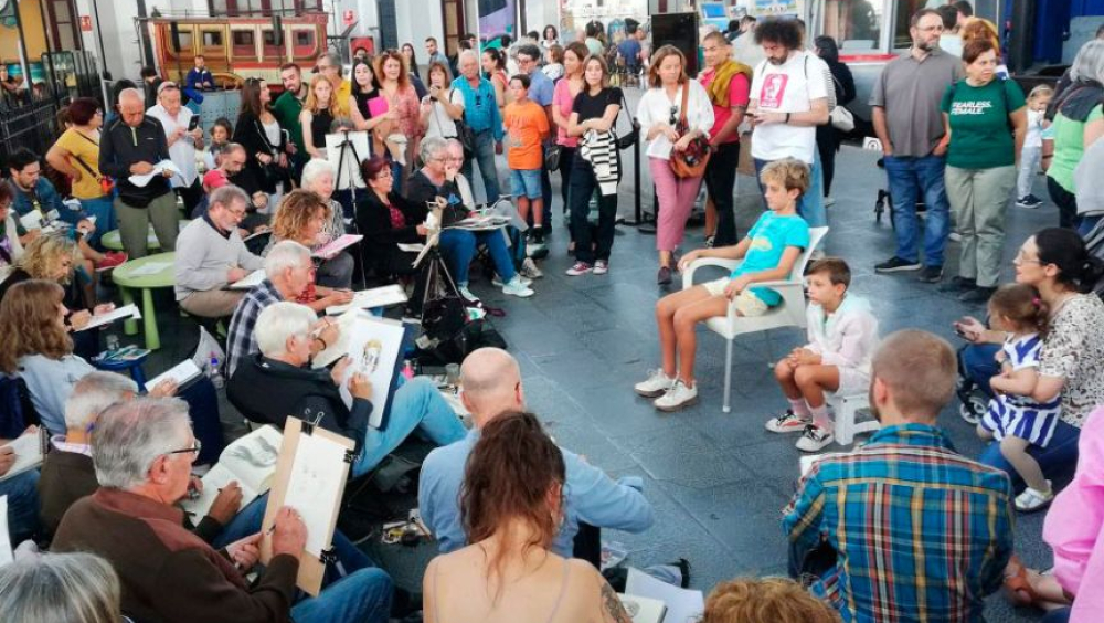 Personas siendo retratadas por un grupo de dibujantes