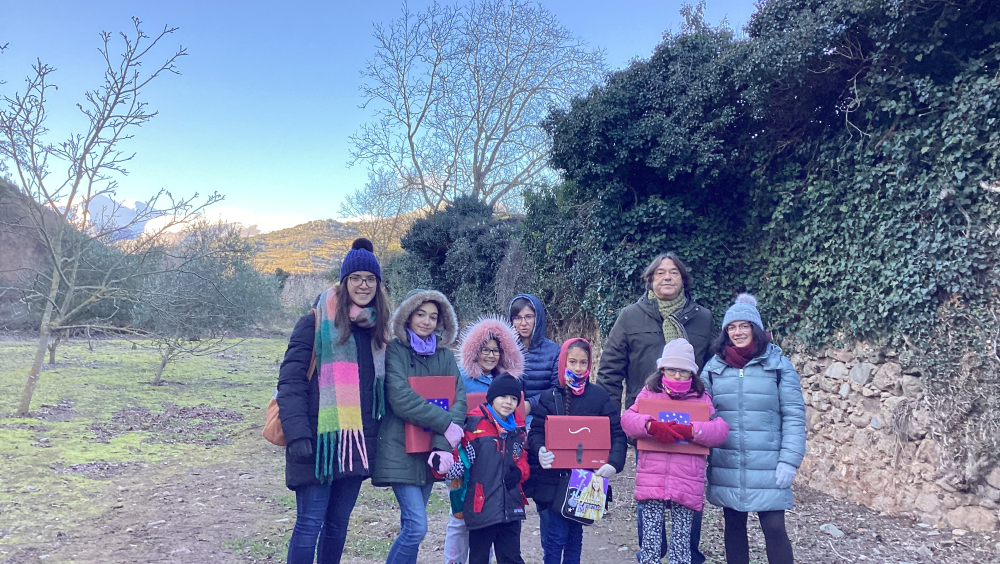 Los alumnos de la escuela de San Millán con sus profesoras y el mentor del proyecto junto a la cerca del Monasterio de Yuso. 
