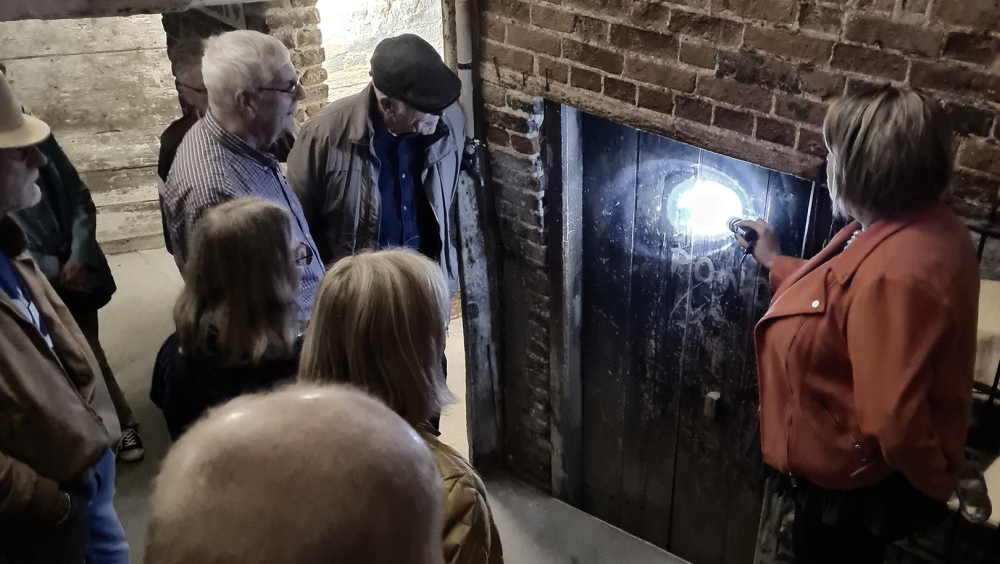  Experience Host pointing out grafitti on a door, from the late 1800s