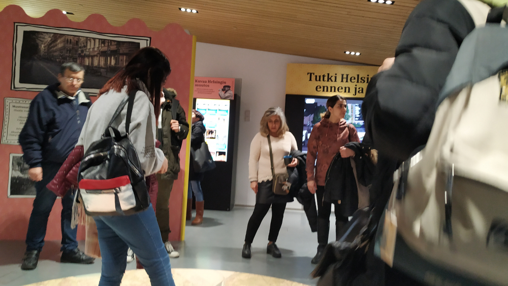 people standing  in  "Helsinki - then and now"  exhibition