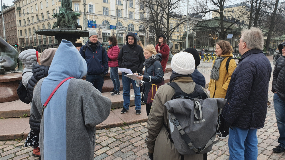 A group is standing at the photowalk next to the Havis Amanda statue.