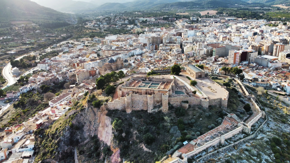 "Aerial view of Onda Castle, showcasing its medieval walls and courtyards, with the modern town and surrounding landscape in the background."