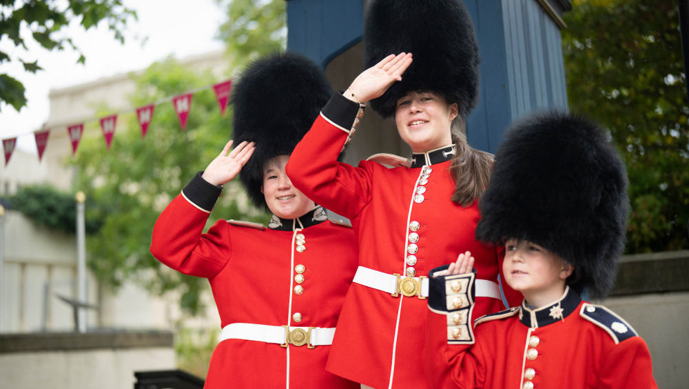 Three children dressed in Guards uniforms.