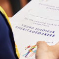 Young European Heritage Makers recognition certificate holding in hand 