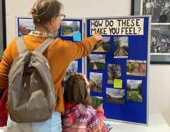 A mother and daughter looking and pointing to a board with images of Rose Hill on them with the text 'how do these make you feel'