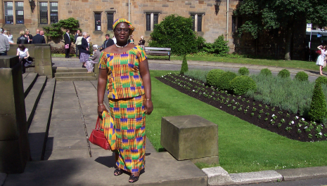 Mary Osei-Oppong in a colourful dress standing in a garden
