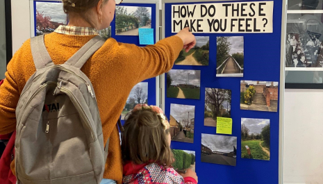 A mother and daughter looking and pointing to a board with images of Rose Hill on them with the text 'how do these make you feel'
