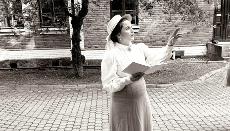 A woman dressed in old-fashioned clothes in a black-and-white photo