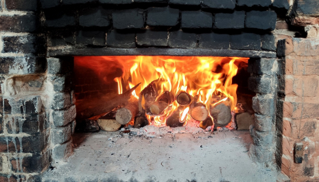 Brood bakken in de houtoven van het gerestaureerde bakhuisken van Bouwel