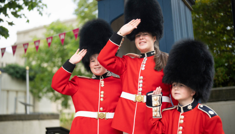 Three children dressed in Guards uniforms.