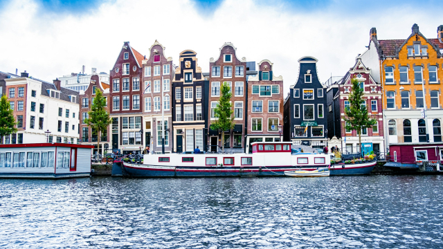 Historic waterfront buildings in Amsterdam (credit, Tobias Kordt via Unsplash)